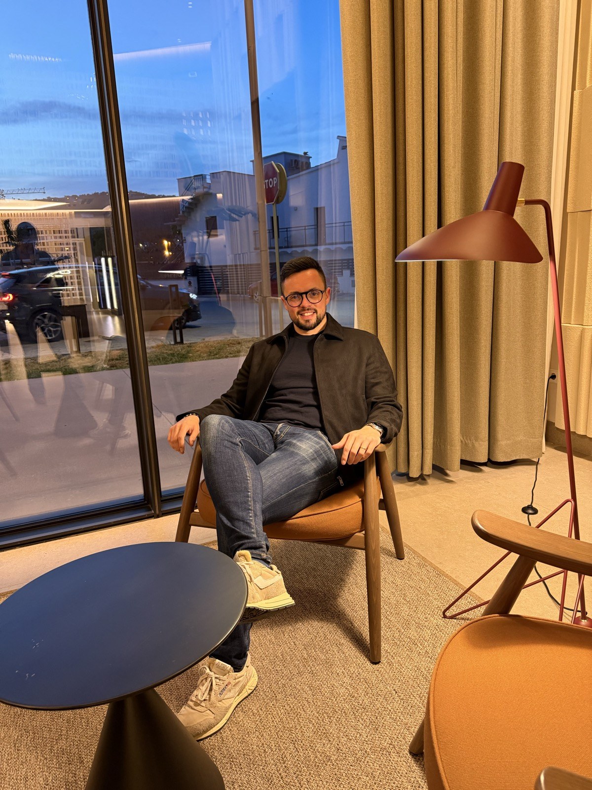 Alex Baño sentado en un sillón junto a una ventana